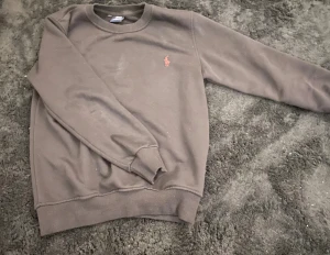 Svart ralph lauren tröja - En svart Polo Ralph Lauren tröja. Tröjan ser grå ut men den är svart (dålig kamera). Ett perfekt alternativ för dig som gillar en avslappnad stil. 