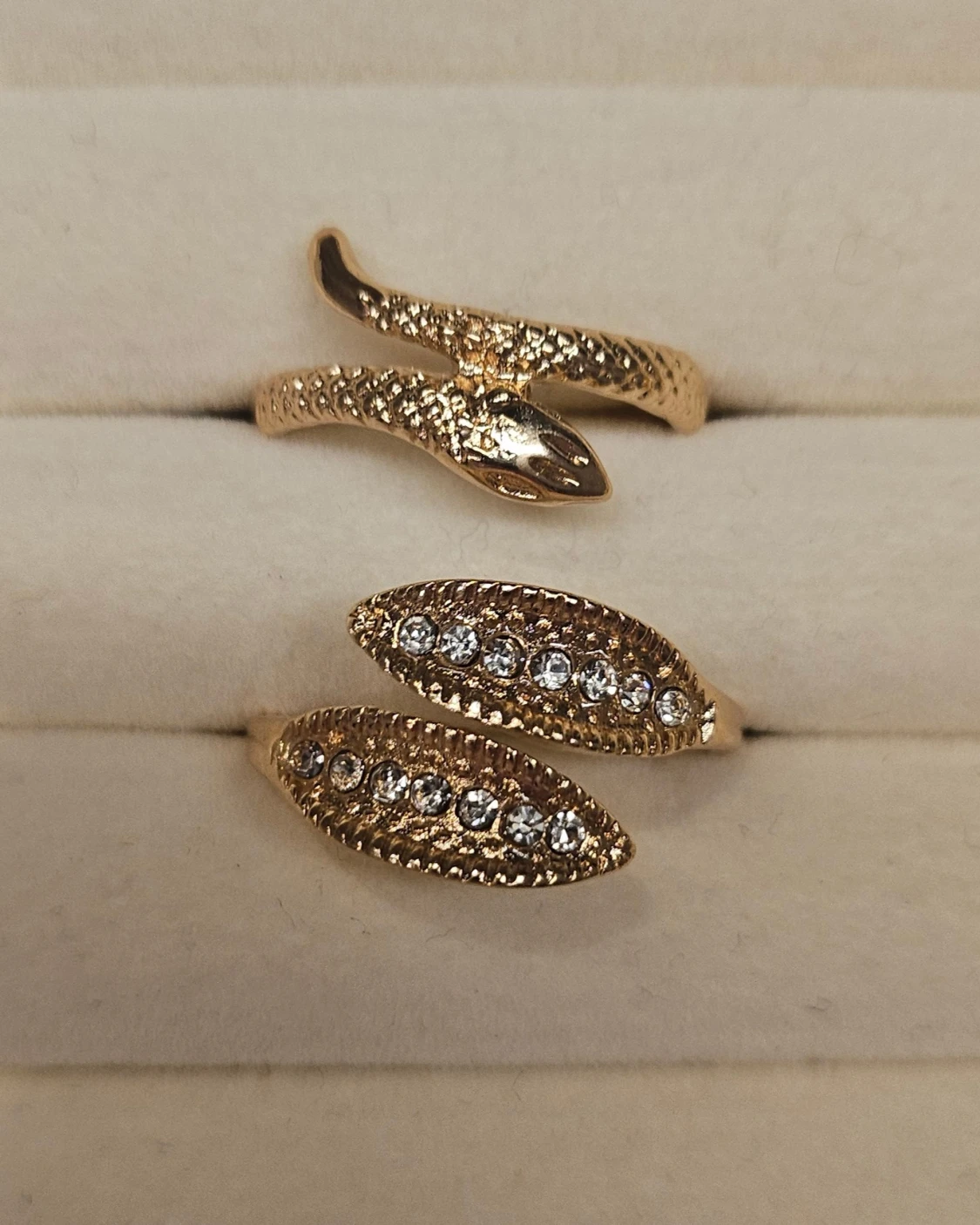 Guldiga ringar med ormdesign och stenar