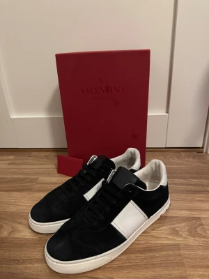 Valentino Garavani svarta sneakers - Tjena! Säljer nu mina valentino Flycrews i färgen svart och storlek 40-41 till ett schysst pris! Skorna är i sin helhet 9/10 i skick och alla nitar finns kvar. Finns inga defekter på skorna. På undersulan är det minimalt slitet vid hälen men ingenting som syns eller påverkas. Äkthetscertifikat finns!! (Allt som syns i bilden ingår). Hör av er vid intresse eller fler frågor! Ha det bäst sålänge!!
