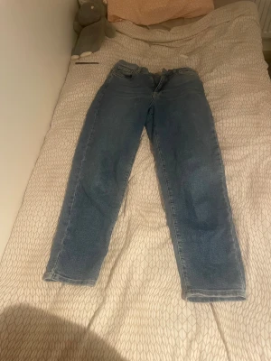 Blå Perfect Jeans från Gina tricot - Snygga blå jeans från Gina Tricot med klassisk femficksdesign och dragkedja. Jeansen har en rak passform och normal midja, tillverkade i slitstarkt denimtyg. Perfekt för dig som gillar en enkel och tidlös stil.