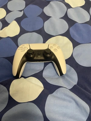 PlayStation 5 DualSense Controller - Snygg och modern PlayStation 5 DualSense-kontroll från Sony. Felfri i vitt och svart utförande, inga synliga repor eller skador. Responsiva knappar och joysticks, USB-C laddning. Perfekt för gaming på PS5 med avancerad haptik och adaptiva triggers.