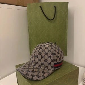 Gucci keps - Snygg keps från Gucci, som inte används alls längre och bara legat. Den är i mycket fint skick och är i storlek M. Det medföljer dustbag och kvitto ingen box och påse!
