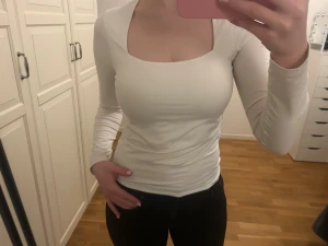 Vit långärmad topp med fyrkantig hals - Basic vit tröja från H&M. Den har fin passform och tyget är mjukt och stretchigt. Den har en väldigt liten fläck på framsidan (se sista bilden) och möjligt någon lös söm, men inga hål eller synliga fläckar osv.