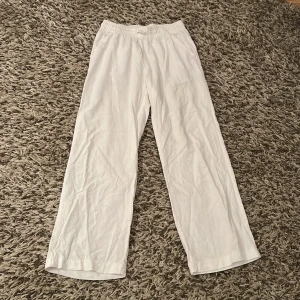 Vita linnebyxor med resårmidja och snörning - Supersnygga vita linnebyxor med avslappnad passform och resår i midjan samt snörning. Byxorna har raka, vida ben, fickor fram och en ficka bak. Perfekta för en chill och stilren look under varmare dagar.💗