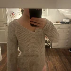 Beige ribbad stickad tröja H&M - Säljer en beige stickad tröja från H&M Basic i storlek XS. Tröjan har ribbad struktur, v-ringad hals och långa ärmar. Perfekt för dig som gillar enkel och stilren design med mjukt material som känns skönt mot huden. Säljer eftersom den inte kommer till användning🫶