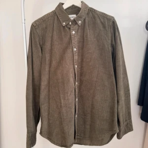 Grön (khaki) manchesterskjorta - Khakifärgad manchesterskjorta (herr) från EastWest i storlek S.