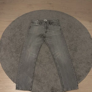 Grå Jack and Jones jeans  - Riktigt snygga grå jeans från Jack and Jones. Jeansen är i storlek 32/34. Skick: 9/10 Vid frågor eller funderingar hör av er!