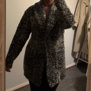 Svartvit teddyjacka med mönster - Säljer en svartvit teddyjacka med grov, mysig struktur och coolt mönster. Jackan har bred krage, långa ärmar och två fickor framtill. Perfekt för dig som gillar oversized och vill ha en jacka som sticker ut i höst och vinter.