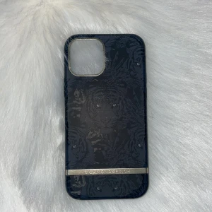 Richmond & Finch Tiger iPhone Case - Skalet passar för iPhone 12. Skalet är i gott skick med mindre tecken på användning invändigt. Perfekt för att skydda din mobil med stil. Fläckarna i mobilskalet går att ta bort!