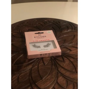 Eylure 3/4 Length Light & Wispy - Säljer ett par Eylure 3/4 Length lösögonfransar i modellen No.011 Light & Wispy. Fransarna är svarta, tunna och ger en naturligt fluffig look. Förpackningen är ljusrosa och inkluderar lim (1 ml). Perfekt för dig som vill ha extra längd och volym.