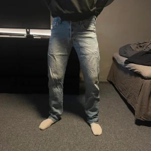 Levi's 501 blå jeans W30 L32 - Klassiska blå Levi's 501 jeans med rak passform och fem fickor. Jeansen har normal midja och är tillverkade i slitstarkt bomullsjeans. Perfekta för dig som gillar en tidlös och avslappnad stil.