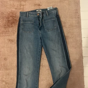 Blå wide jeans från Wrangler - Snygga blå jeans från Wrangler med raka, vida ben och klassiska fickor fram.  Mörkblåa streck på sidorna storlek 27:34