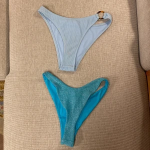 Två bikiniunderdelar från Bik Bok - Säljer två blå bikiniunderdelar från Bik Bok. En ljusblå ribbad med ringdetalj i sidan och en glittrig turkosblå med ännu högre midja. Båda för 80kr eller den ena för 40kr!