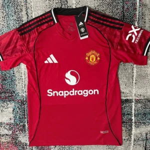 Manchester United Adidas matchtröja M - Manchester Uniteds officiella matchtröja från Adidas i rött med svarta och vita detaljer. Tröjan har klubbmärke på bröstet, Snapdragon-sponsor, svarta ränder på axlarna och vit Adidas-logga. Tillverkad i lätt funktionsmaterial med korta ärmar och svartvit krage.