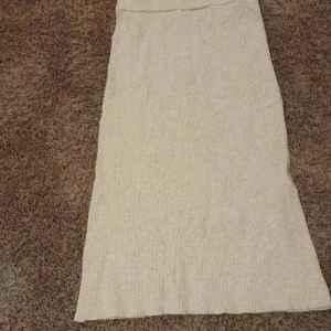 Beige ribbad långkjol från Vila - Säljer en beige ribbad långkjol från Vila i storlek XS. Kjolen är stickad och har en mjuk, skön känsla med en enkel och stilren look. Perfekt för dig som gillar en avslappnad men ändå trendig stil.