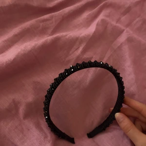 Svart diadem med glittriga pärlor - Snyggt svart diadem med glittriga pärlor som ger en cool och exklusiv känsla. Diademet har en struktur av små svarta pärlor. Perfekt för att lyfta din look och hålla håret på plats. Passar dig som gillar att sticka ut med accessoarer eller ba lyfta en simpel outfitt. 💕💕 Väldigt bra skick eftersom har använt den ba några få gånger. 