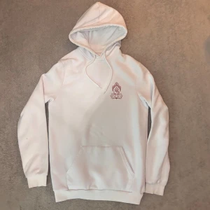 Vit hoodie  - Säljer en vit hoodie från YOURTURN med stor färgglad drake och japanska tecken på ryggen. Tröjan har huva med snörning, magficka och lång ärm. Perfekt för dig som gillar streetstyle och unika prints.