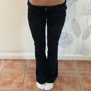 Svarta True Religion Joey flare jeans - Säljer ett par svarta Joey Low Rise Flare jeans från True Religion. De har låg midja, utsvängda ben och klassiska detaljer som fickor med knapp bak. Snygg passform och cool look, perfekta till sneakers eller boots. Använt 4 gånger så nästan helt nya i storlek 24. Som referens är jag 168cm