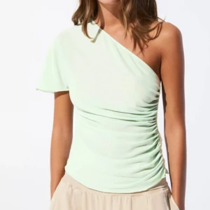 Ljusgrön oneshoulder topp - Snygg ljusgrön topp med oneshoulder-design och lätt rynkade detaljer längs sidan. Strl s endast testad!🥰🥰