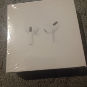 AirPods Pro - Säljer ett par helt nya AirPods Pro i oöppnad originalförpackning. Trådlösa hörlurar med aktiv brusreducering och laddningsetui. Perfekt skick, plasten är kvar på kartongen. Passar alla Apple-enheter och ger fantastisk ljudupplevelse.