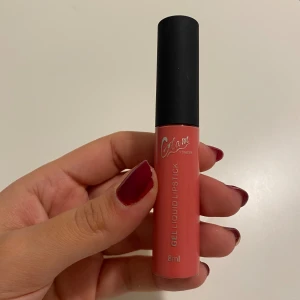 Glam Sweden gel liquid läppstift - Säljer ett gel liquid läppstift från Glam Sweden i en snygg korallrosa nyans. Tuben rymmer 8 ml och har en svart matt kork med applikator. Konsistensen är krämig och ger ett glansigt resultat. Perfekt för dig som gillar färgstarka läppar med mjuk finish.
