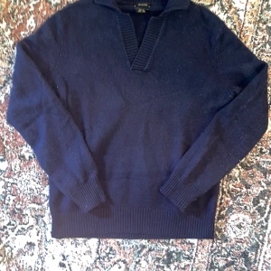 Marinblå stickad tröja Massimo Dutti - Snygg marinblå stickad tröja från Massimo Dutti med v-ringad krage och ribbade muddar. Kragen kan bäras uppåt eller neråt. Passar dig som vill ha en clean look. Nytt skick. Storlek L men sitter som M