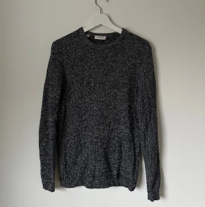 Svartvit stickad tröja Selected Homme - Säljer en svartvit stickad tröja från Selected Homme i storlek M. Tröjan har ett grovt melerat mönster, rund hals och långa ärmar. Perfekt för dig som gillar enkel och stilren design med lite textur. Passar dig som vill ha en klassisk look. 5H15