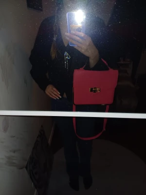 Rosa axelväska med gulddetalj - Säljer en snygg rosa axelväska med stilren, fyrkantig form och guldfärgat spänne framtill. Väskan har både handtag och justerbar axelrem, perfekt för att bära crossbody. Skriv för fler frågor ❤️