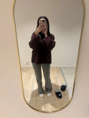 Grå kostymbyxor från BikBok, stl 34 - Snygga grå kostymbyxor från BikBok i storlek 34. Byxorna har raka ben med lätt bootcut, hällor för bälte och klassisk kostymlook. Perfekta för dig som gillar stilrena och trendiga vibes. Materialet känns mjukt och följsamt.