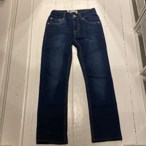 Levi's 511 jeans junior  - Snygga Levi's 511 jeans i mörkblå denim. Klassisk femficksdesign med knapp och dragkedja framtill. Perfekta för en stilren look.