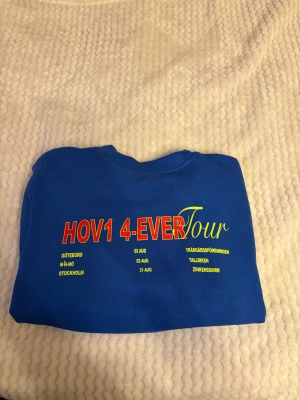 Blå Hov1 4-Ever Tour sweatshirt M - Blå sweatshirt från Hov1 med tryck 'HOV1 4-EVER Tour' i rött och gult på ryggen samt en liten krona broderad på bröstet. Rund hals och mjukt material🪼