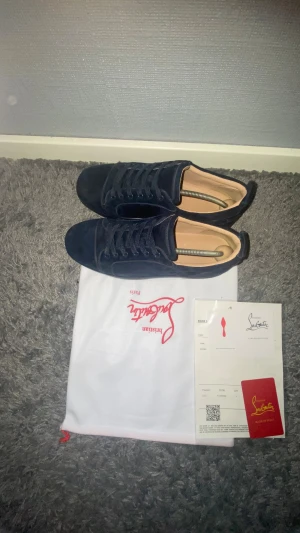Mörkblå sneakers från Christian Louboutin  -  Säljer ett par Louboutin mörkblå,Snygga mörkblå sneakers från Christian Louboutin. Jag har tyvär tappat bort sko kartongern. Dem är inte äkta och fortfarande fint skick. Skorna är inte äkta !