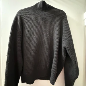 Svart ribbad polotröja - Mysig svart polotröja med ribbad struktur och hög krage från Massimo Dutti. Tröjan har en  långa ärmar, perfekt till alla dagar och outfits!!!