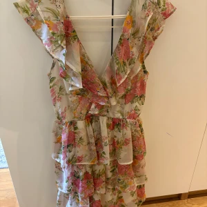 Blommig volangklänning från NLY Eve - Superfin blommig kortklänning från NLY Eve med volanger och v-ringad hals.