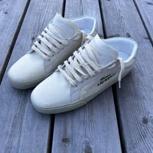 Ysl sneakers - Hej! Jag säljer ett par  lite använda Saint Laurent Court Lows i vit färg. Endast skor medföljer. Tveka inte att ställa frågor. Säljes för 1999 kr. Storlek 43. Normal i storleken. Jag har kvittot. Bud är välkomna.