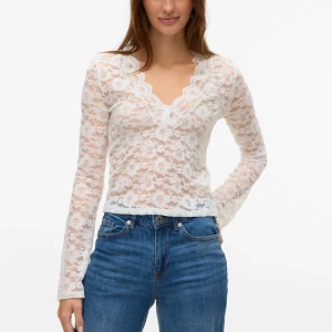 Vit spetsblus med v-ringning - Säljer en vit blus i spets med v-ringad hals och långa ärmar. Blusen är figurnära och har ett transparent, blommigt spetsmönster som ger en romantisk vibe. Perfekt att styla med både kjol och jeans för en trendig look. Från Vero Moda, använd några enstaka gånger💕orginalpris 429.90kr