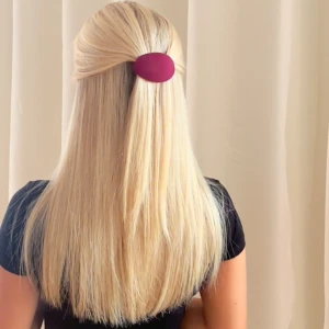 Burgundi hårklämma  - Säljer en ovalformad vinröd hårklämma. Klämman är täckt av tyg och har en metallspänne på baksidan för enkel fastsättning i håret. Perfekt för att ge en stilren och trendig look till din frisyr. Den är gjord av återvunna skedar och återvunnet tyg. 