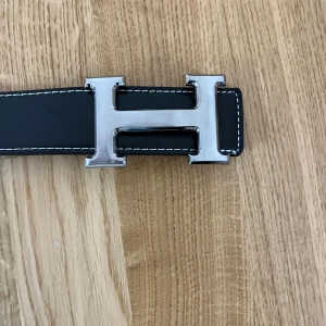 Svart H-spänne bälte  - Säljer svart bälte med H loga