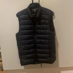 Uniqlo väst - Säljer en fet dunväst från uniqlo. Västen ör  i  storlek M och färgen är mörkblå. Västen har inga tecken på användning, skriv vid minsta funderingar!