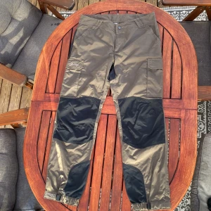 Lundhags gröna vildmarksbyxor W's 42 - Säljer ett par gröna vildmarksbyxor från Lundhags i storlek 42. Byxorna har svarta förstärkningar på knän, bak och benslut, samt stora fickor på sidorna. Perfekta för friluftsliv, vandring och skogsutflykter. Slitstarka, väldigt bekväma och klassisk Lundhagskvalitet.