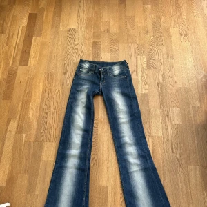 Blå bootcut jeans från Weekday, Cheap Monday - Snygga blå bootcut jeans från Cheap Monday med ljusa partier framtill och baktill. Klassisk femficksmodell med normal passform och låg midja. Jeansen är tillverkade i denim och har en cool vintagekänsla. Köpte på Vinted men var för stora för mig! 