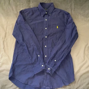 Blå skjorta från Polo Ralph Lauren - Mörkblå skjorta från Ralph Lauren i storlek S. Fint skick till ett bra pris. Nypris: 1995kr. Mitt pris: 299kr                  Vid frågor eller funderingar, tveka inte att höra av dig.