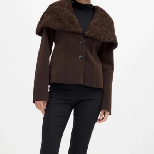 Brun kappa med teddykrage - Säljer den slutsålda jackan från Lovisa worges kollektion med NAKD. Endast använd 1 gång.