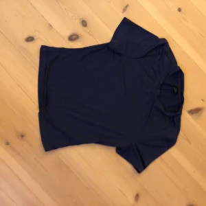 Mörkblå t-shirt från SHEIN - En enkel och stilren mörkblå t-shirt från SHEIN i storlek S. T-shirten har rund hals och korta ärmar, perfekt för en chill och avslappnad look. Materialet känns mjukt och lätt mot huden, vilket gör den skön att bära hela dagen.