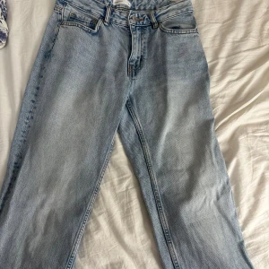 Straight ljusblå jeans, strl 34 - Snygga ljusblå jeans från gina tricot. Byxorna har rak passform och hög midja, med slitstarka sömmar och silverfärgade detaljer. Straight jeans som är lite korta för någon som är 174. 