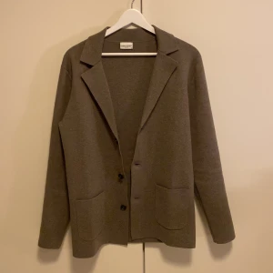 Cardigan/kavaj från John Henric - Säljer min cardigan/kavaj från John Henric då jag inte andväder eller knappast har använt den. Nypris: 1000. Den är i nyskick då jag endast använt den en gång. Färgen är TAUPE!, men vet inte vad er är i förhållande till de man kan välja på. Är dock lite ”brunaktig”