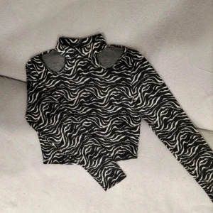 mönstrad svartvit långärmad topp med cutout - svartvit mönstrad långärmad topp med cutouts vid halsen! storlek S. hör av er vid frågor!! 