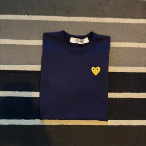 Comme des Garçons tshirt - navy/guld - Tjena! Säljer nu denna CDG tshirten. Fint skick, använd 2-3 gånger då den inte passar. Storlek S. Pris går att diskuteras vid snabbaffär 