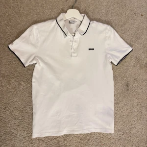Vit BOSS pikétröja - Vit pikétröja från BOSS med svart logga. Jätte clean look och passar även XS/S. Pris kan diskuteras