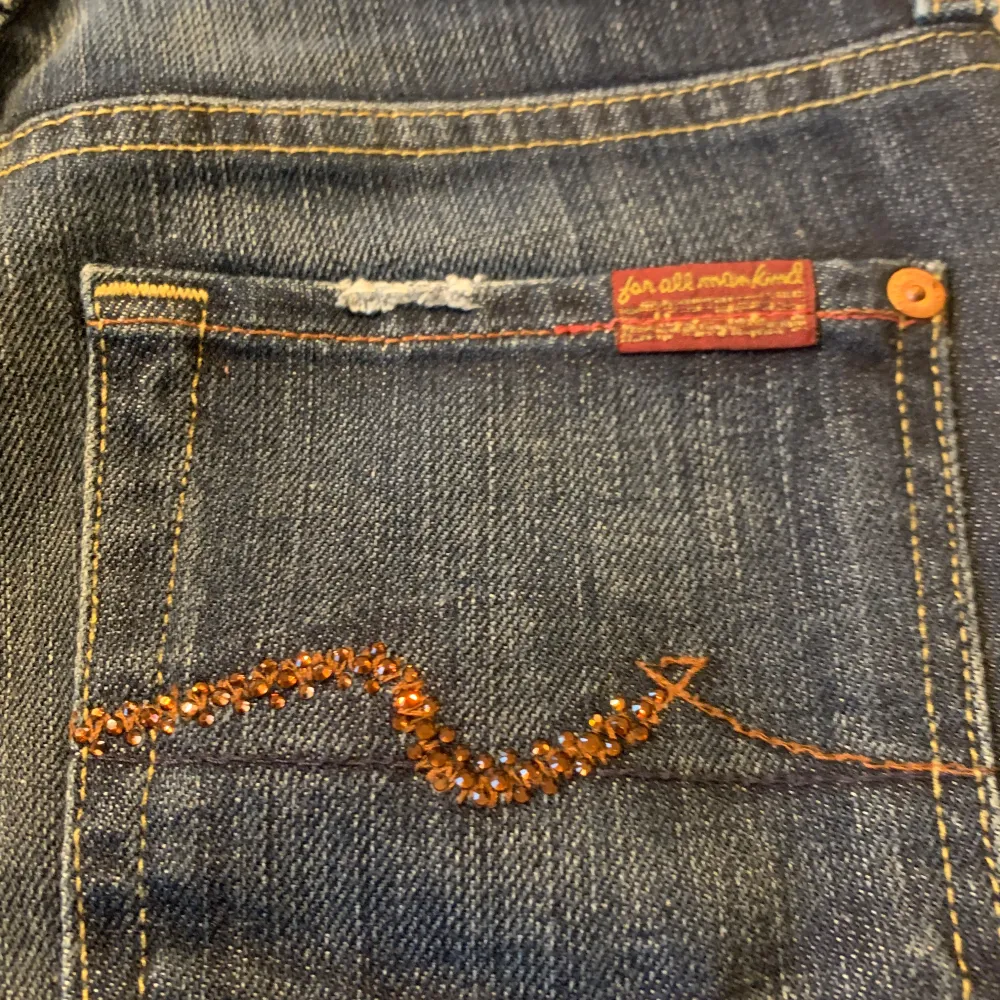 Grymt snygga jeans från USA , 7 For All Mankind med stenar/kristaller på bakfickan. De är i bra skick. Säljer pga att de är för små för mig. Storlek 26. Jeans & Byxor.